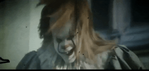 a close up of a clown with red hair and a white collar .