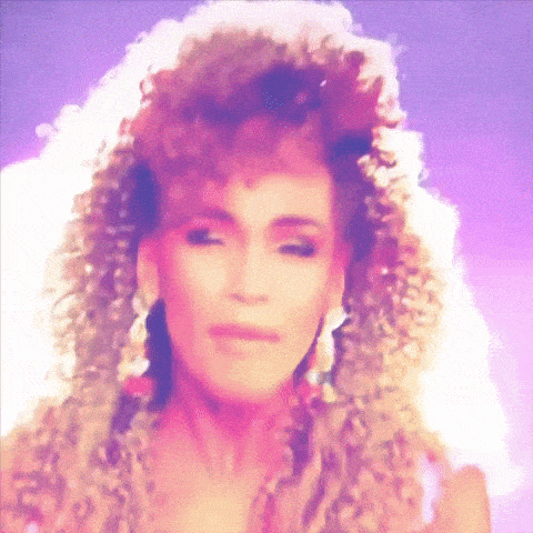 a close up of a woman 's face with curly hair and earrings