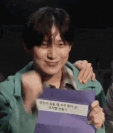 a man is holding a purple piece of paper and smiling .