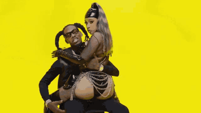 a man and a woman are posing for a picture with a yellow background