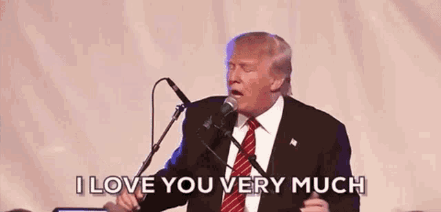 a man in a suit and tie is singing into a microphone .