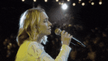 a woman singing into a shure microphone on stage
