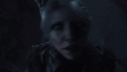a close up of a woman 's face with a very dark background