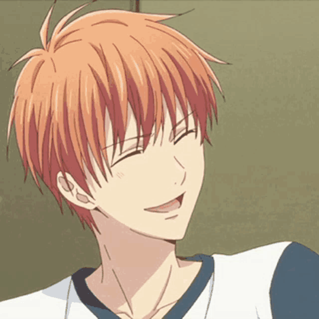 a close up of a boy with orange hair smiling with his eyes closed .