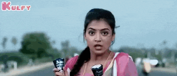 a woman is holding two ice cream cones in her hand and making a funny face .