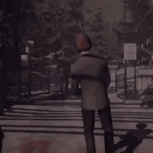 a man in a suit is walking down a street .