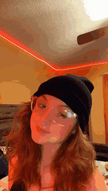 a girl wearing a beanie and glasses is looking at the camera