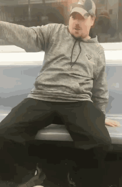 a man is sitting on a bench with his legs crossed