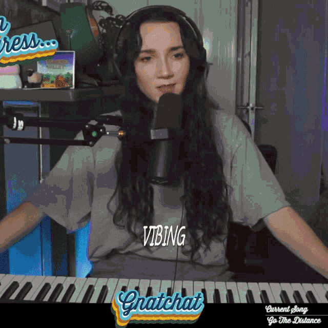 a woman singing into a microphone while wearing a shirt that says vibing on it