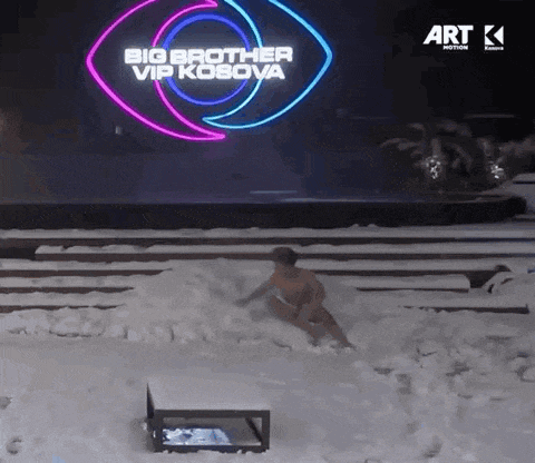 a man is laying in the snow in front of a big brother sign