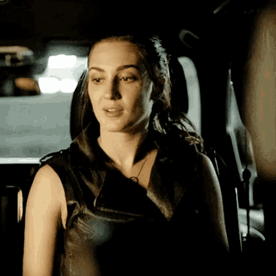 a woman is sitting in the back seat of a car looking out the window .
