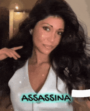 a woman with long black hair is wearing a white shirt and has the word assassina written on her chest