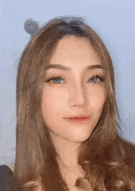 a close up of a woman 's face with long hair and a shower head in the background .