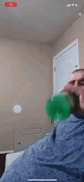 a person is holding a green bottle in their hand and the time is 8:35