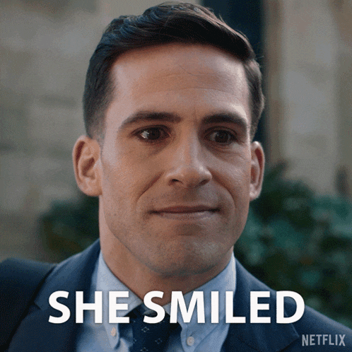 a man in a suit and tie is smiling with the words she smiled behind him