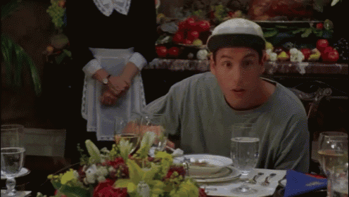 a man is sitting at a table with plates and glasses