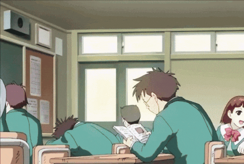 a group of students are sitting at desks in a classroom with one reading a book