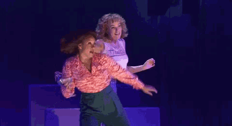 a couple of women are dancing on a stage