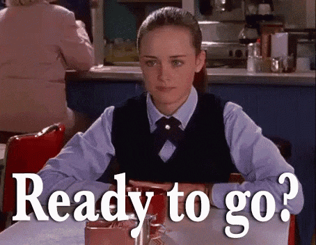 a woman is sitting at a table with the words `` ready to go '' written on the table .