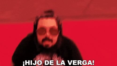 a man with a beard and sunglasses is standing in front of a red background and says hijo de la verga !