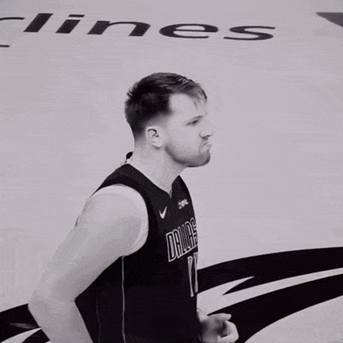 a basketball player wearing a mavericks jersey stands on the court