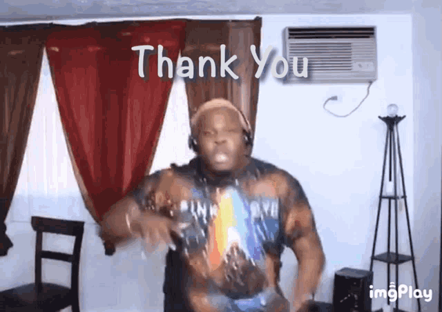 a man wearing headphones is dancing in a living room with the words thank you behind him