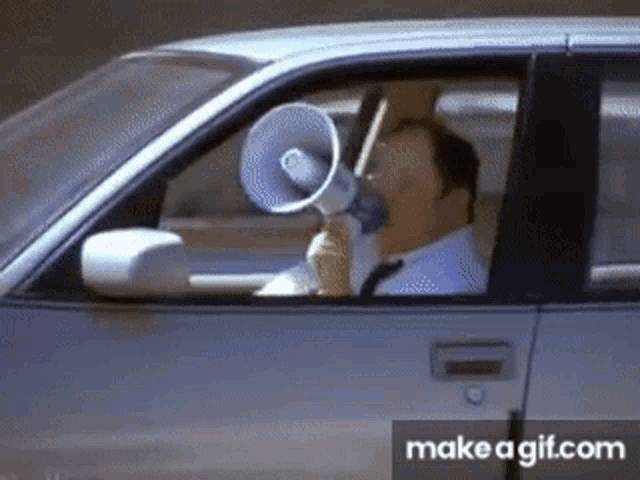 a man in a car is using a megaphone