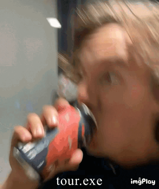 a close up of a person drinking from a can with tour.exe written below it