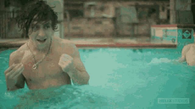 a man without a shirt is swimming in a pool with helixstudios written on the bottom
