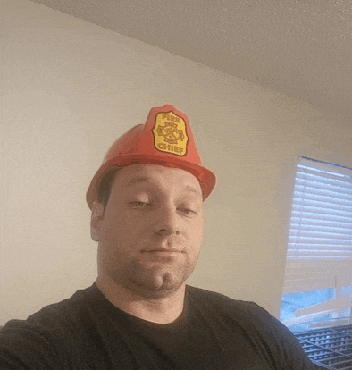 a man wearing a red fireman 's helmet with the word chiefs on it