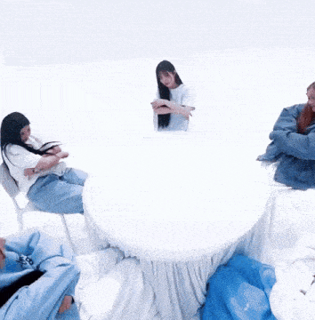a group of people are sitting around a table with a woman standing behind them .