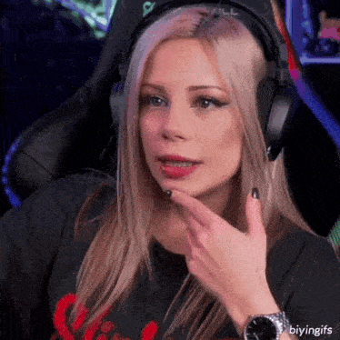 a woman wearing headphones and a watch is making a funny face .