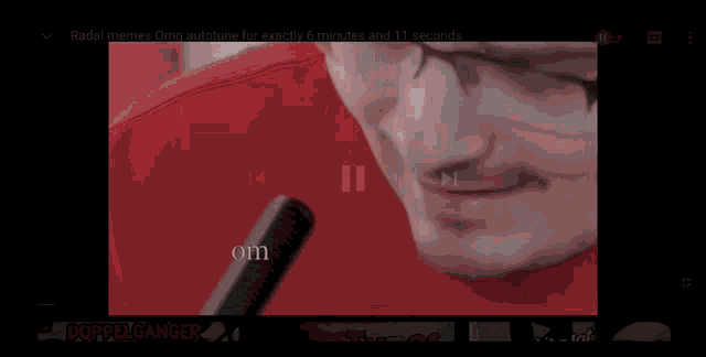 a man wearing headphones and a red shirt with a puma logo is playing a flute .
