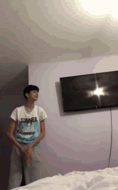 a person wearing a shirt that says summer is standing in front of a tv