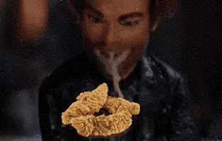 a woman is eating chicken nuggets in a dark room .