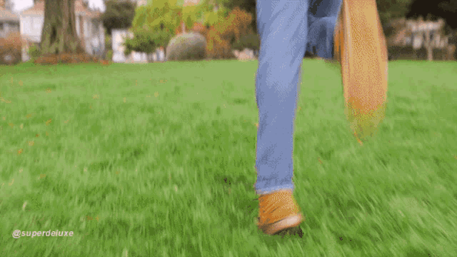 a blurry picture of a person running in a grassy field with the caption superdeluxe