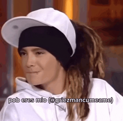a woman with dreadlocks wearing a white hat and a white hoodie