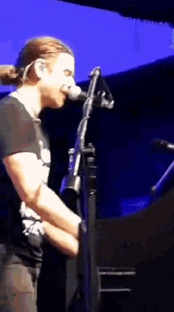 a man is singing into a microphone on a stage