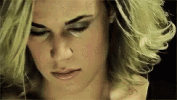 a close up of a woman 's face with her eyes closed and her hair blowing in the wind