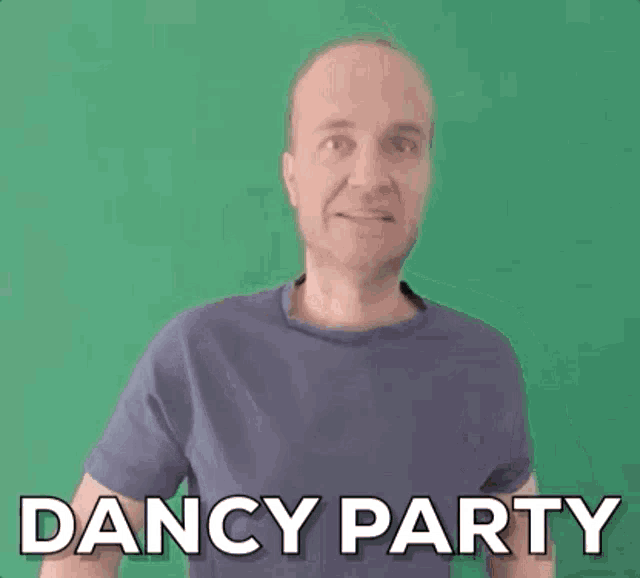 a man in a blue shirt is standing in front of a green wall and saying dancy party .