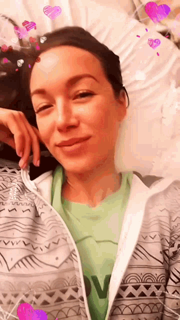 a woman wearing a green shirt with the letter v on it is smiling