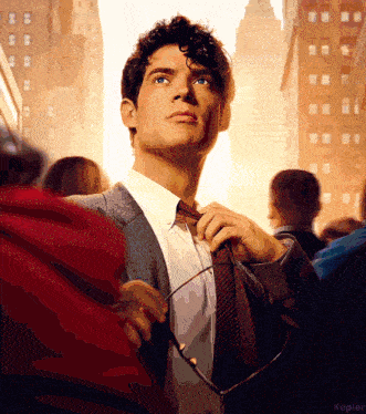 a man in a suit and tie adjusts his tie in front of a crowd of people