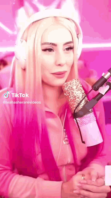 a woman wearing headphones and holding a microphone with tiktok written on the bottom