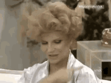 a woman with curly hair is sitting in a bathtub .