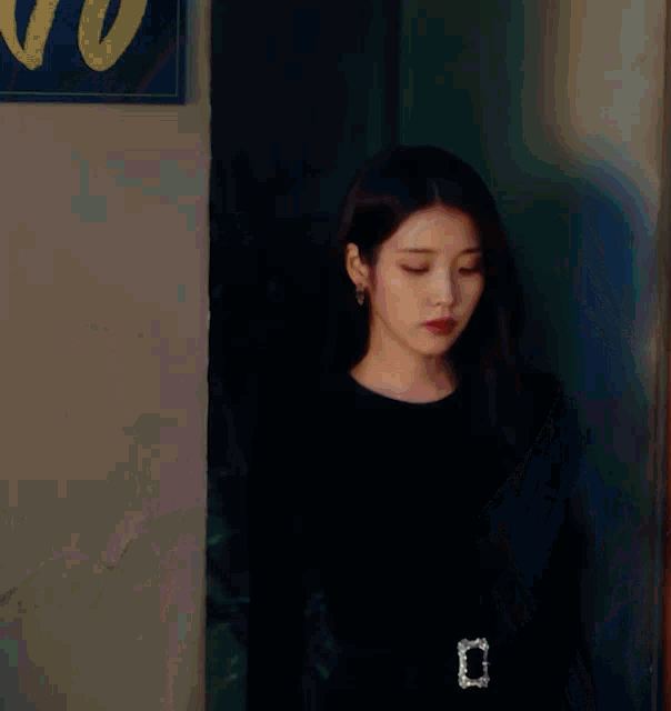 a woman in a black dress with a bow on her waist