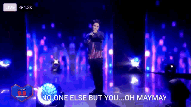 a man singing into a microphone with the words " no one else but you oh maymay " below him