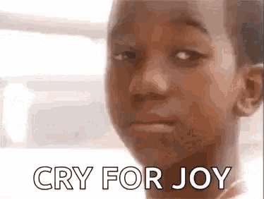 a young boy is crying for joy and making a funny face .