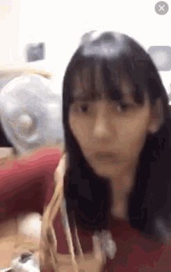 a young girl is sitting at a table with a fork in her hand and making a funny face .