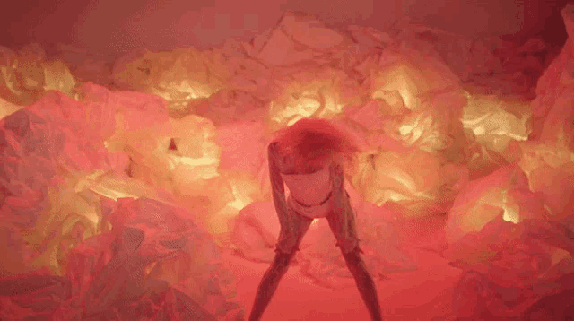 a woman is standing in the middle of a pile of red and yellow papers