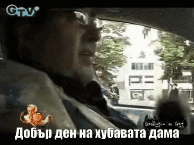 a man is sitting in a car with a foreign language on the screen